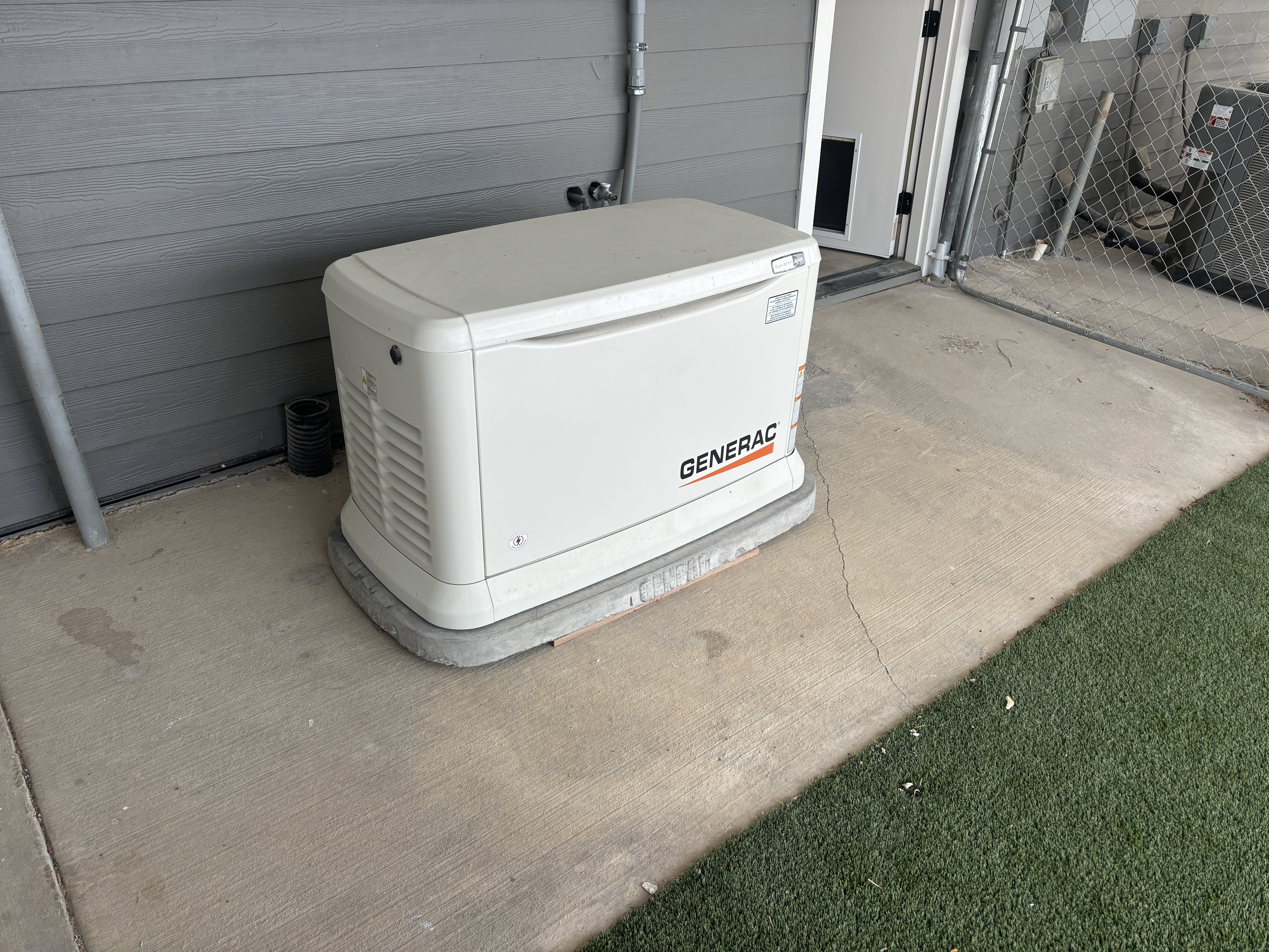 Installed Generac home standby generator beside a home